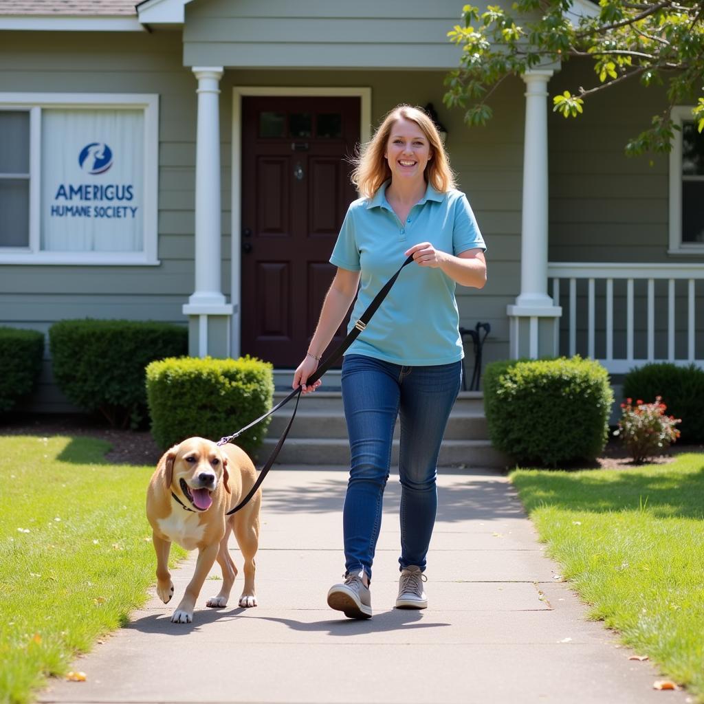 Volunteer walking a happy dog at the Americus Humane Society