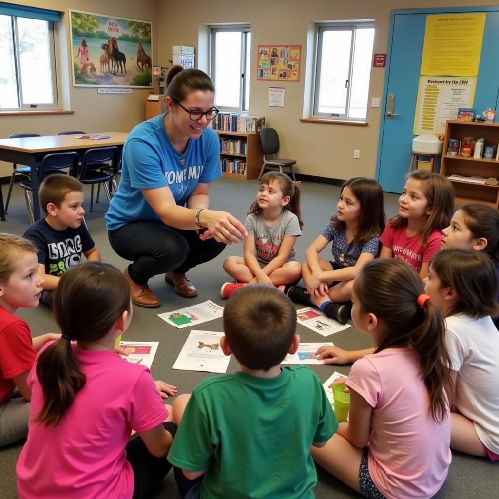 A group of children listening attentively to a camp counselor during an educational session at the AZ Humane Society Summer Camp.