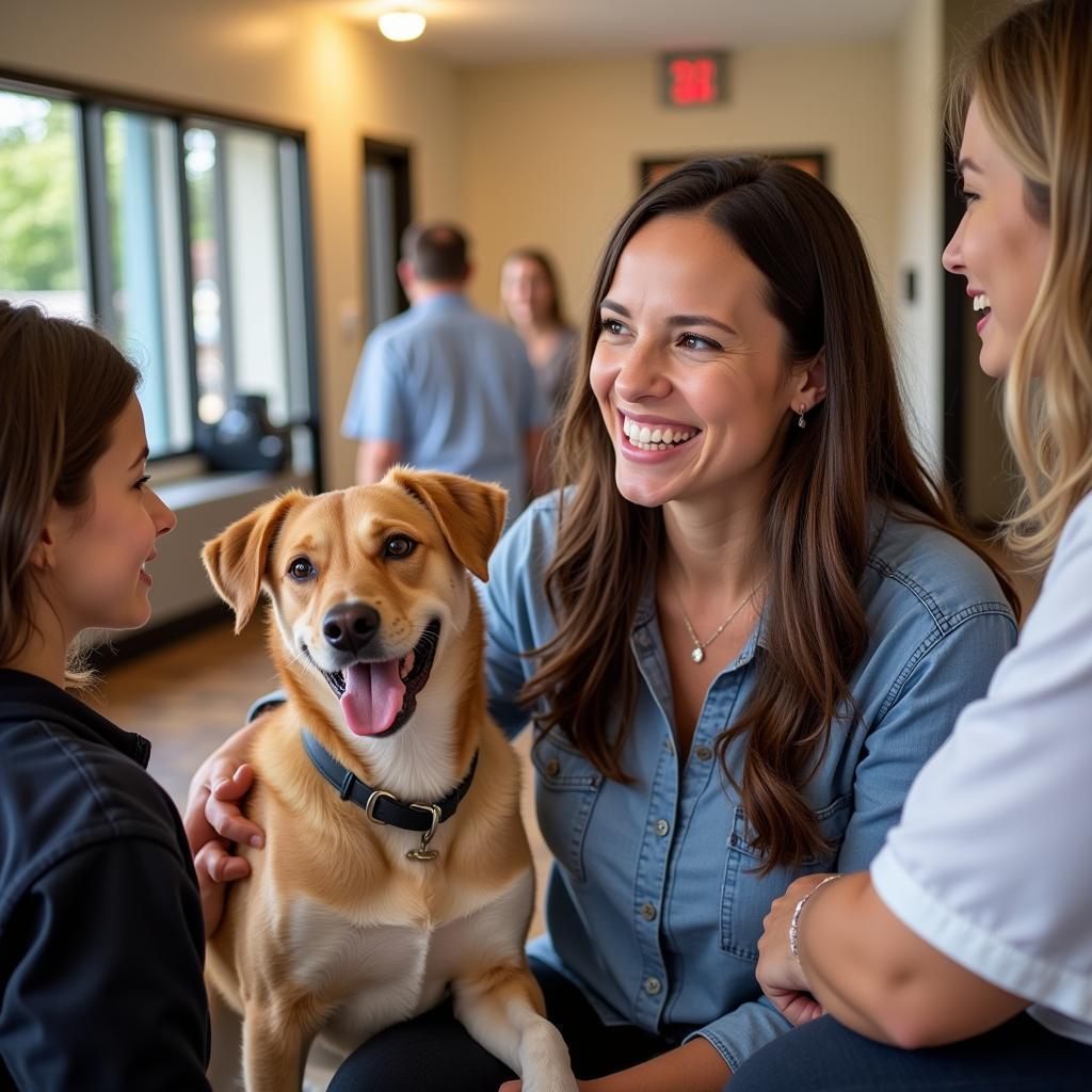 Smiling adoption counselor talks with a family and their new dog