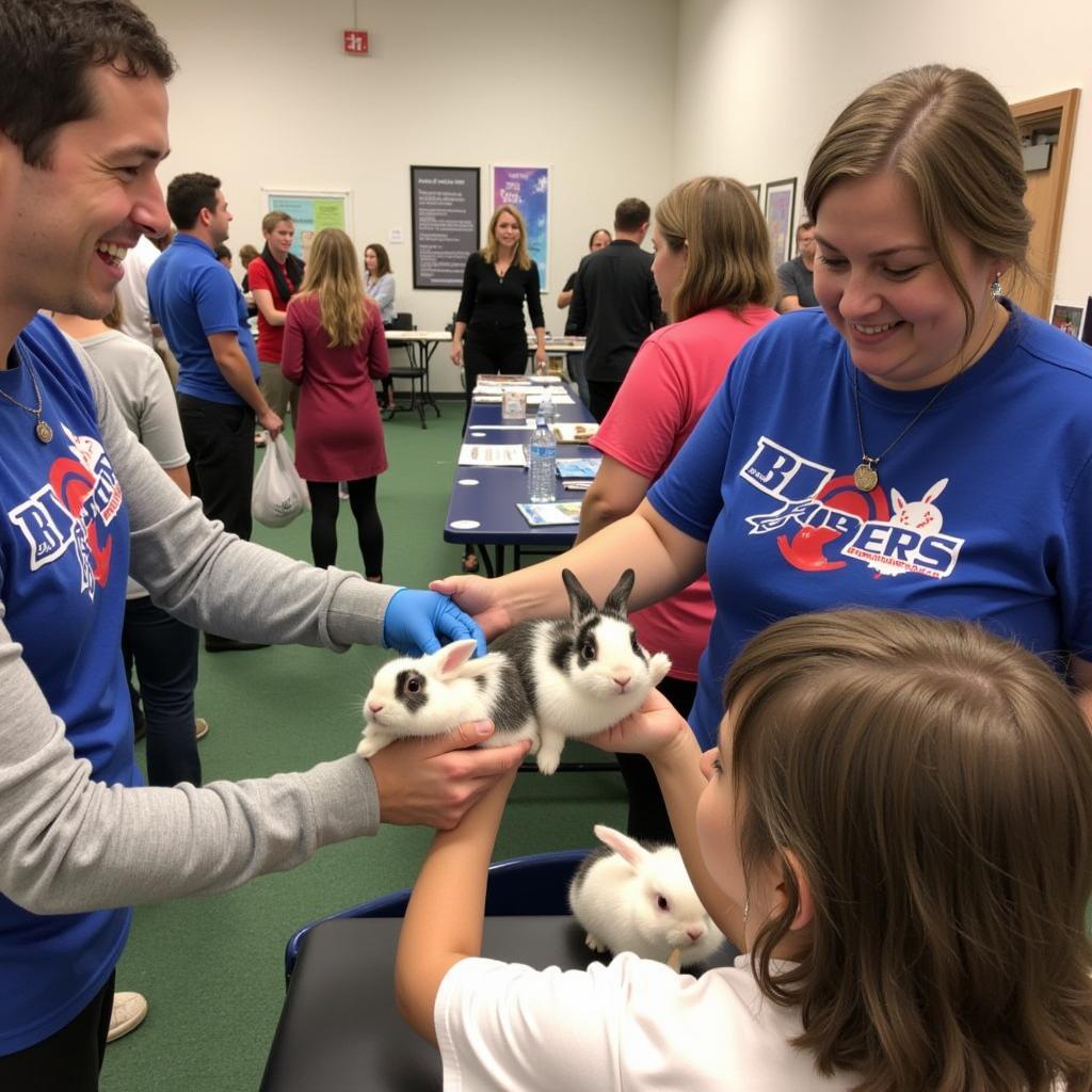 Volunteers at a Buckeye House Rabbit Society adoption event interacting with rabbits and potential adopters