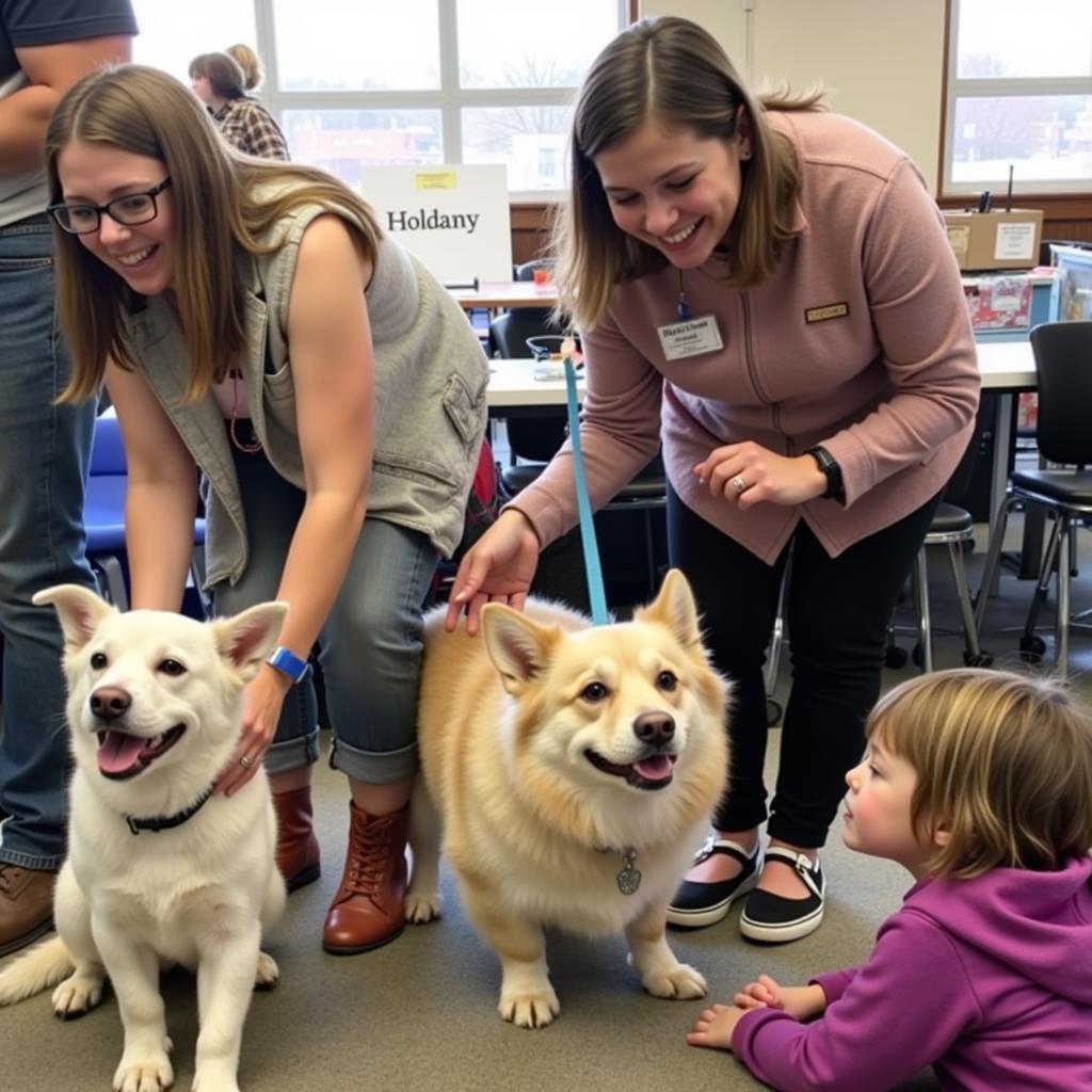 Families interacting with animals at a Decorah Iowa Humane Society adoption event.