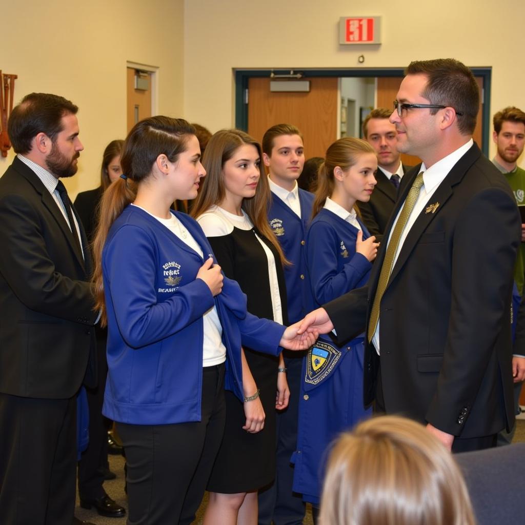 Students receiving their National Junior Honor Society shirts at an induction ceremony.