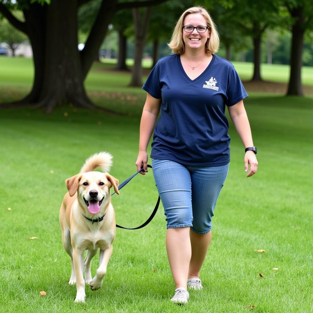 Volunteer walking adopted dog