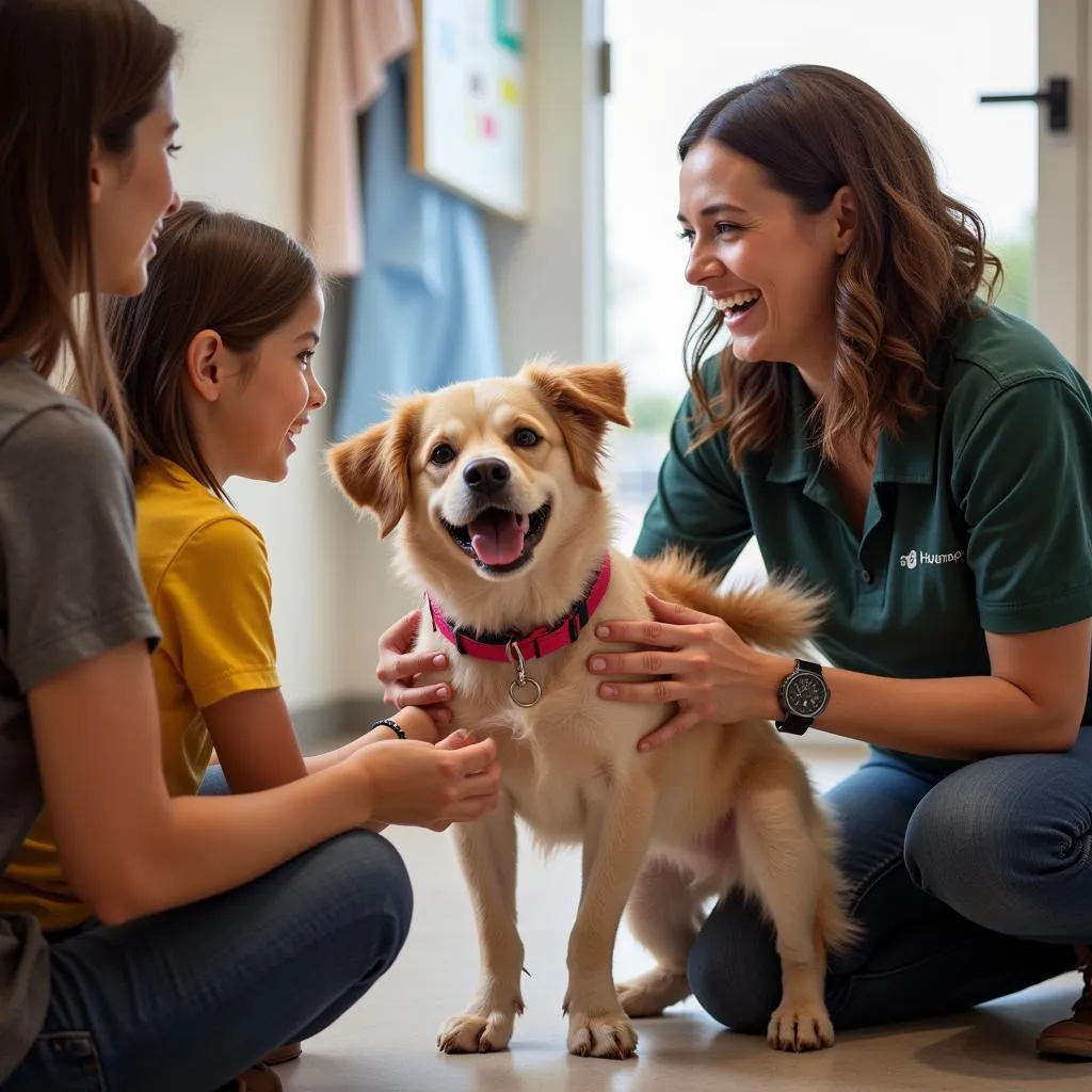 An adoption counselor introducing a family to a playful dog at the SD Humane Society El Cajon