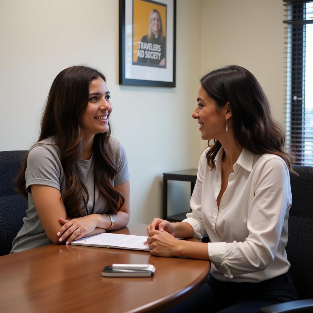 A Travelers Aid Society counselor providing support to a young woman at their office