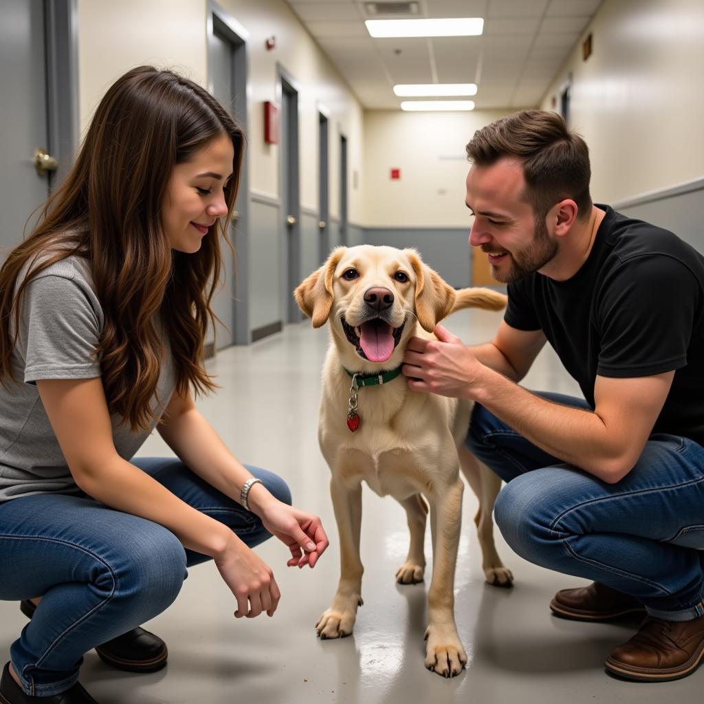 A family interacting with a playful dog during a meet-and-greet at the Tri-County Humane Society.