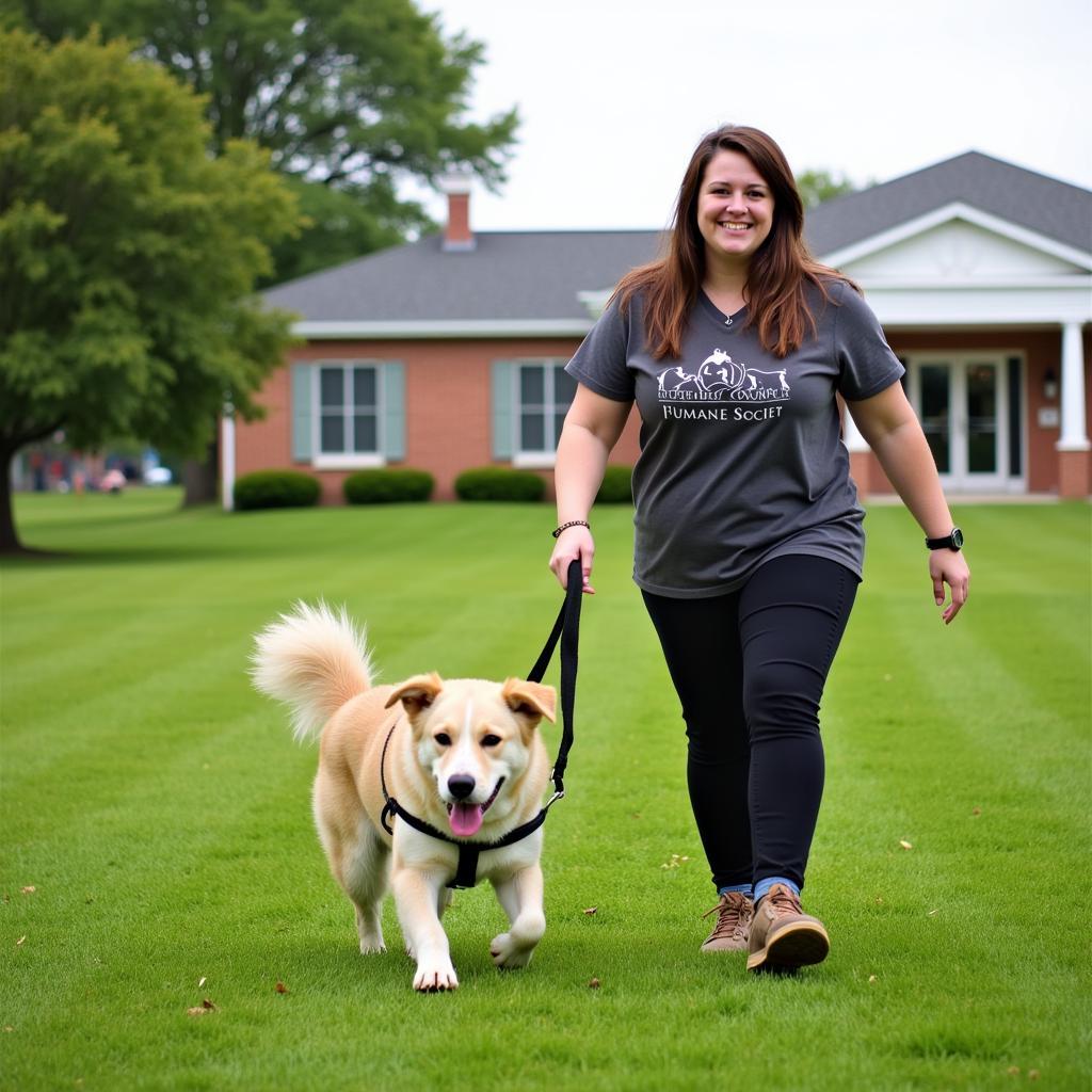 Volunteer walking a dog at the Elmore County Humane Society